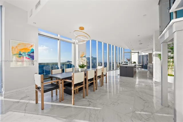 a dining room with furniture and a floor to ceiling window