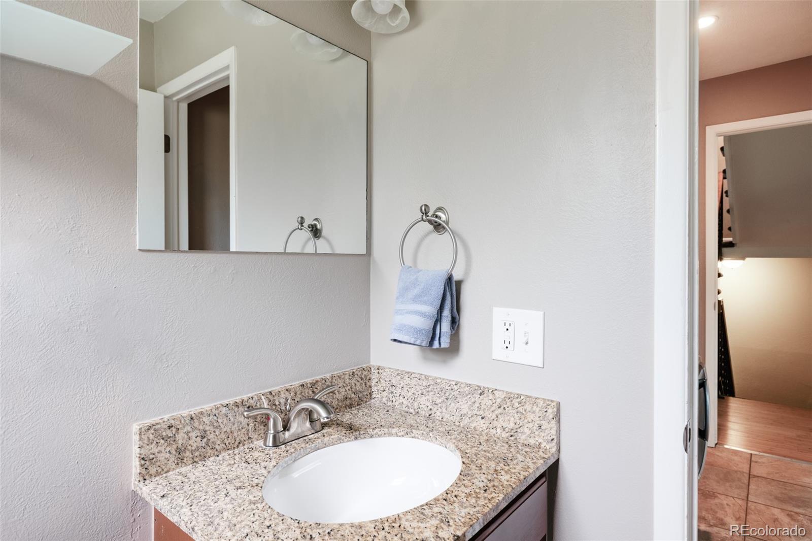 7448 West Roxbury Place Littleton, CO 80128 - Photo 13 of 30 a bathroom with a granite countertop sink and a mirror