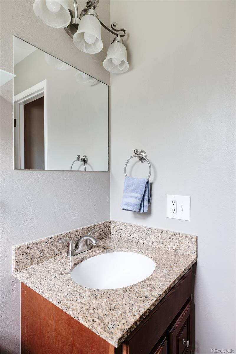 7448 West Roxbury Place Littleton, CO 80128 - Photo 14 of 30 a bathroom with a granite countertop sink and a mirror