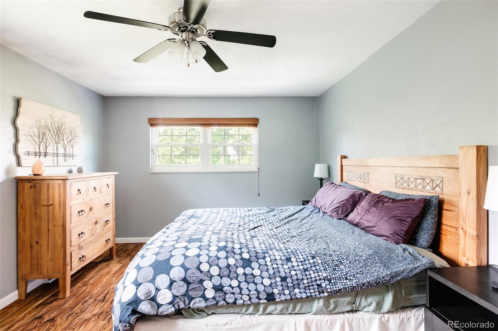 7448 West Roxbury Place Littleton, CO 80128 - Photo 17 of 30 a bedroom with a bed and a chandelier