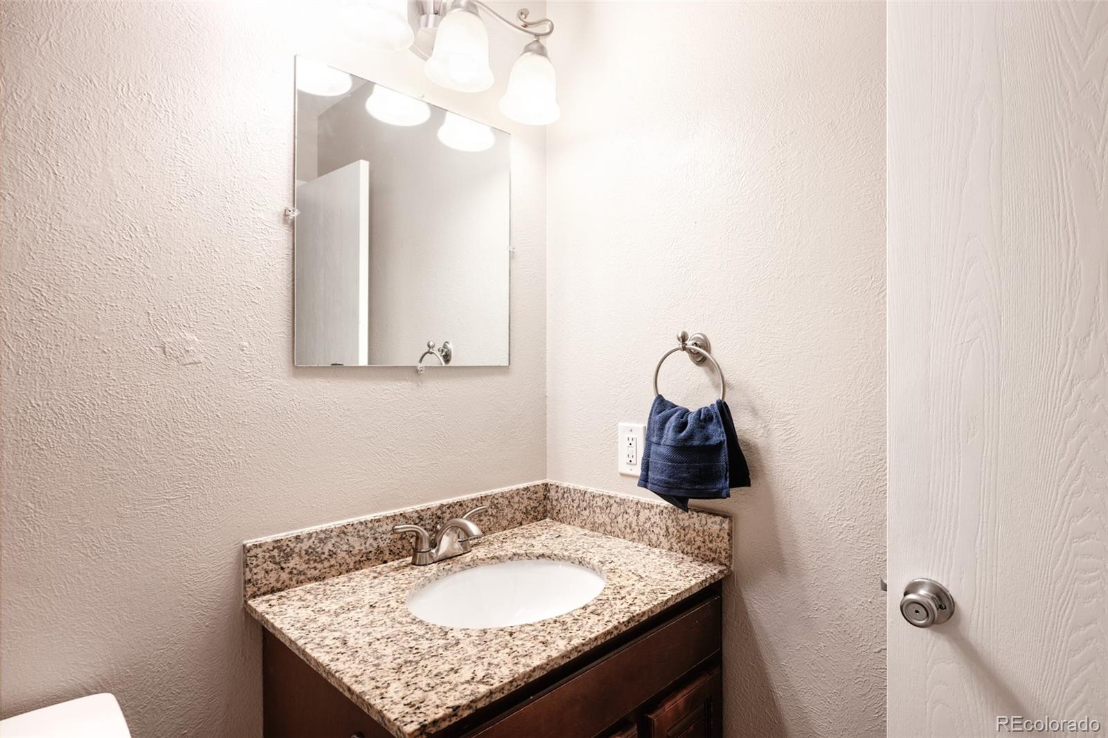 7448 West Roxbury Place Littleton, CO 80128 - Photo 24 of 30 a bathroom with a granite countertop sink and a mirror