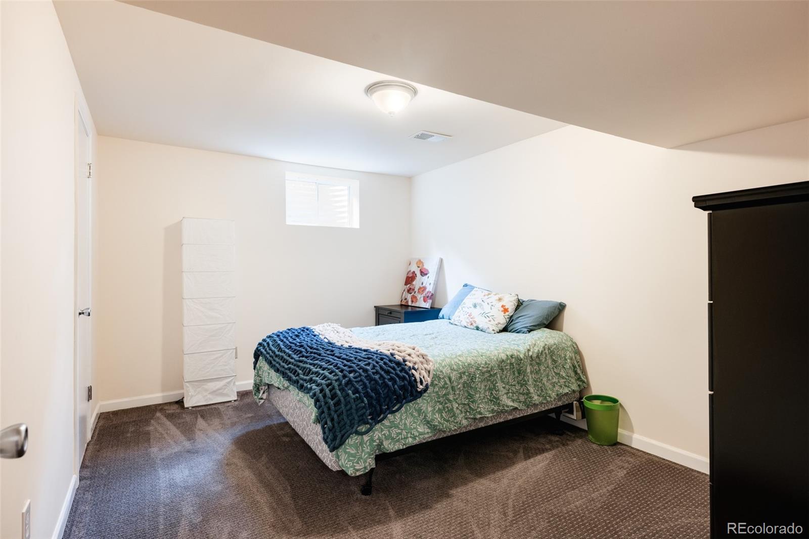 7448 West Roxbury Place Littleton, CO 80128 - Photo 27 of 30 a bedroom with a bed and wooden floor