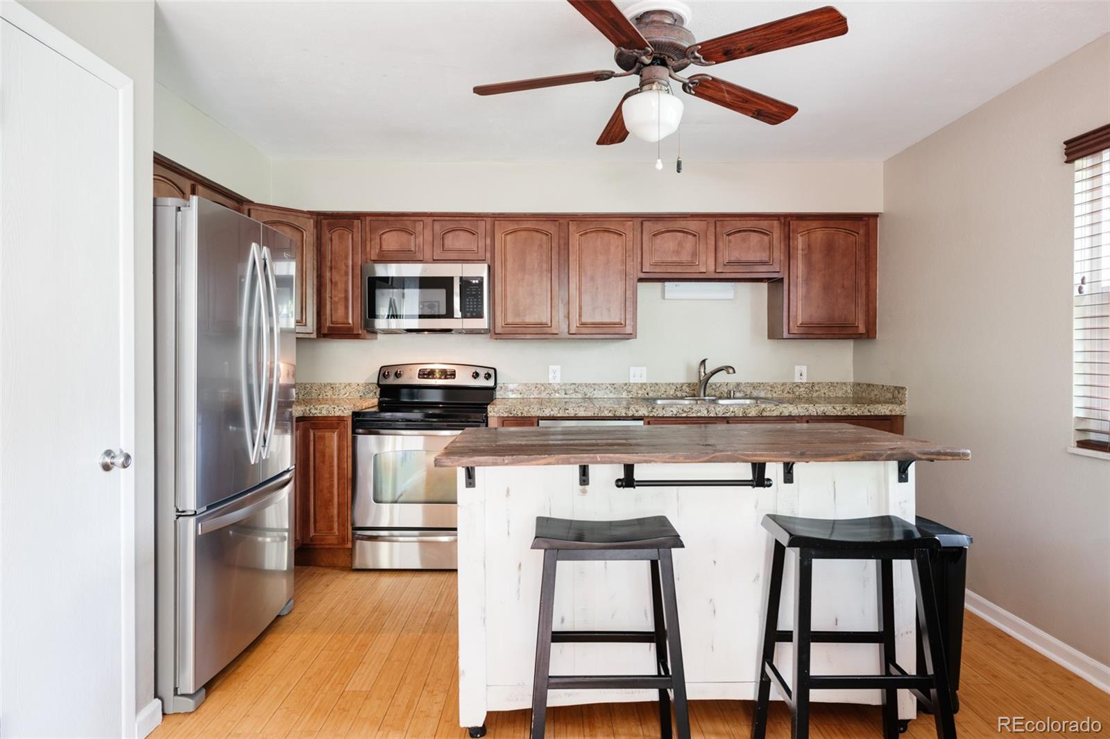 7448 West Roxbury Place Littleton, CO 80128 - Photo 7 of 30 a kitchen with stainless steel appliances granite countertop a stove a sink and a refrigerator