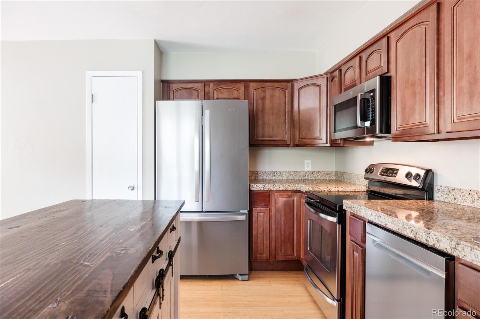7448 West Roxbury Place Littleton, CO 80128 - Photo 10 of 30 a kitchen with stainless steel appliances granite countertop a refrigerator a stove top oven a sink and dishwasher