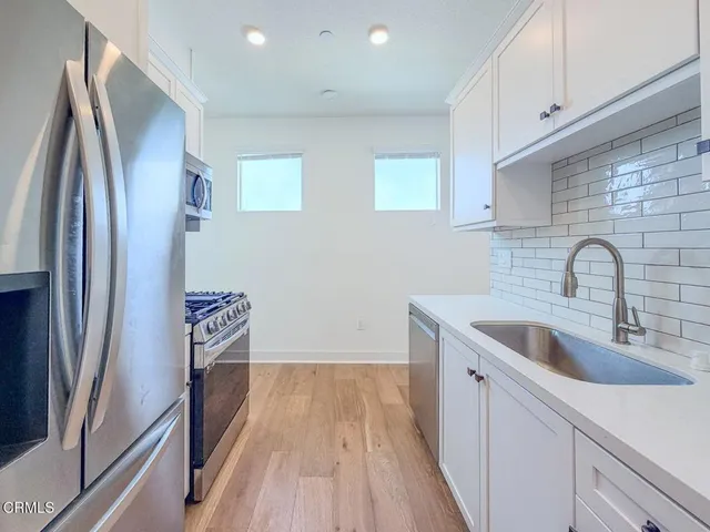 a kitchen with sink a refrigerator and cabinets