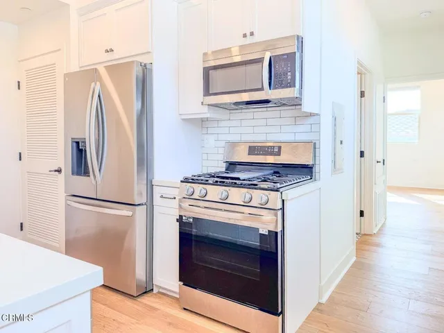 a kitchen with stainless steel appliances a stove microwave and a refrigerator