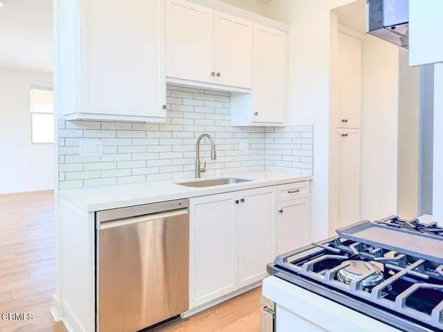 a kitchen with sink stove and cabinets