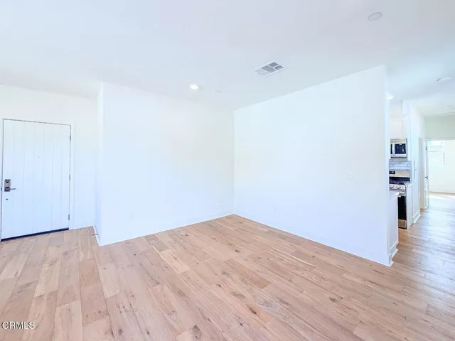 a view of empty room with wooden floor