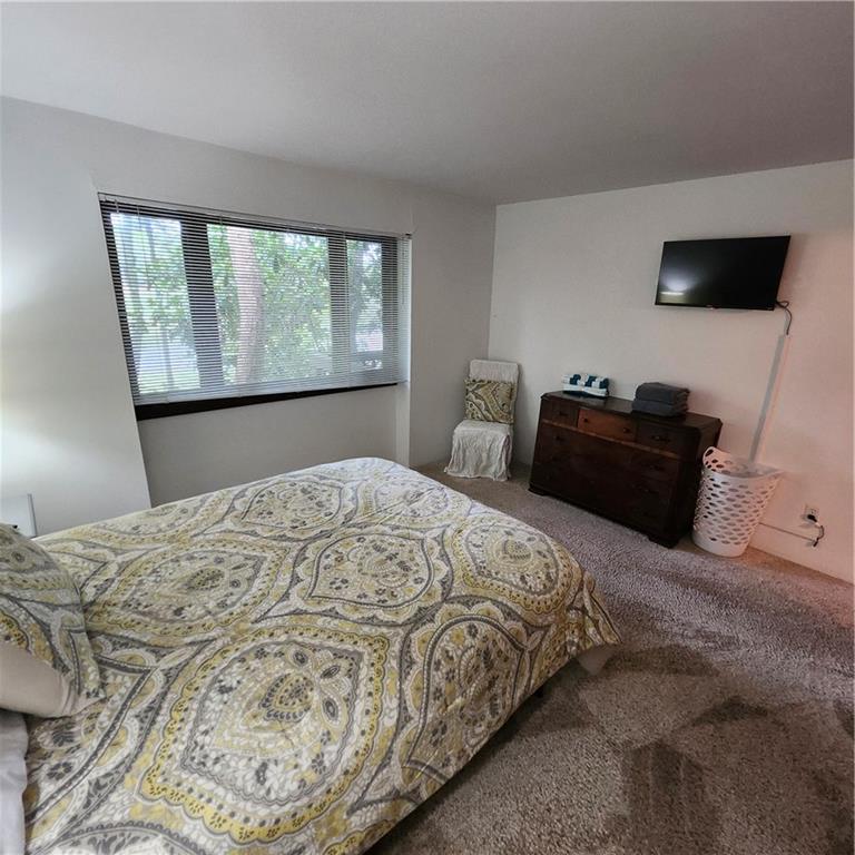 34 Sconti Ridge, Unit 405 Jasper, GA 30143 - Photo 9 of 14 a bedroom with a bed and a flat tv screen on a dresser