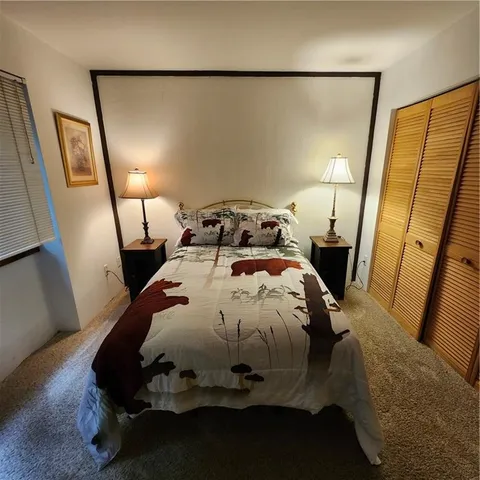 a bed sitting in a bedroom next to a lamp