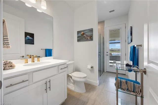 a view of bathroom with a sink mirror toilet and next to a window
