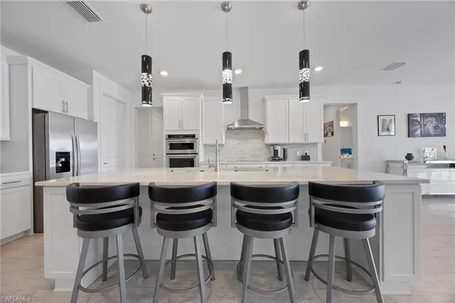 a kitchen with stainless steel appliances kitchen island granite countertop a table and chairs