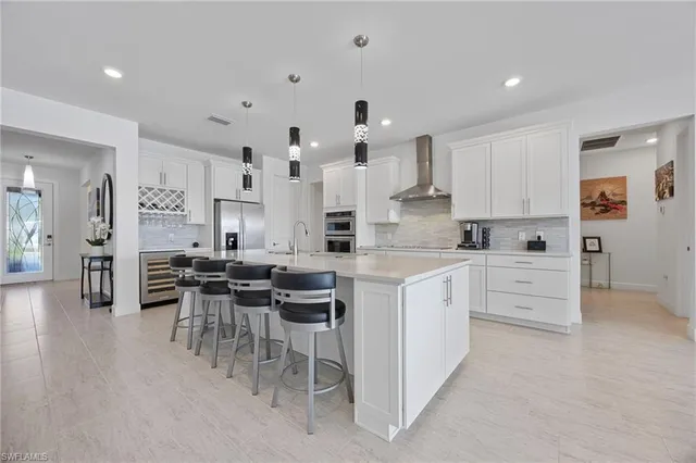 a kitchen with white cabinets and chairs