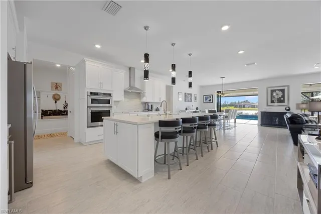 a kitchen with appliances and chairs in it
