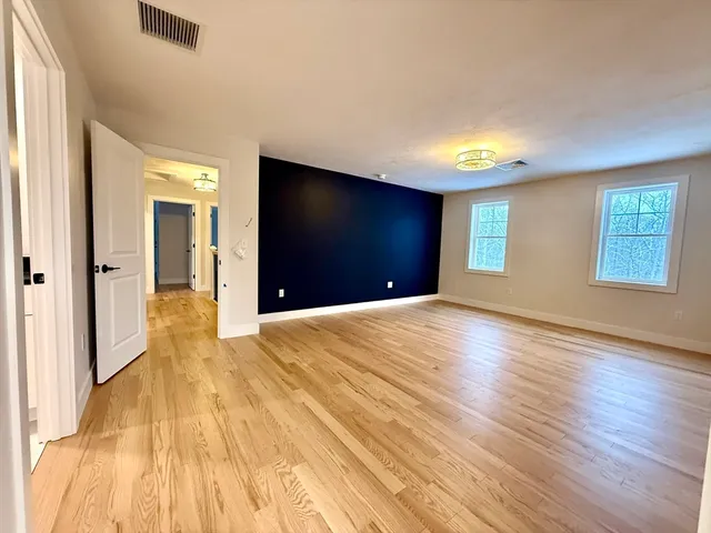 a view of a livingroom with wooden floor and a window