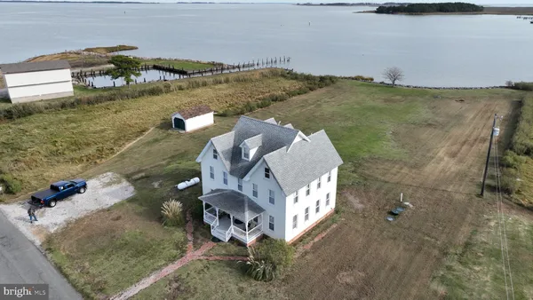 an aerial view of a house with a yard and lake view
