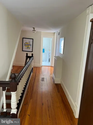 a view of a hallway with wooden floor and staircase