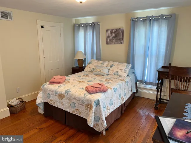 a bedroom with bed and wooden floor
