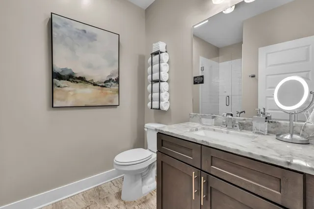a bathroom with a granite countertop sink mirror vanity and toilet