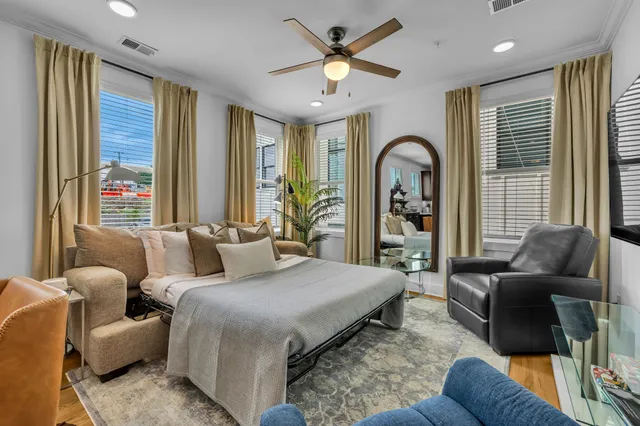 a bedroom with furniture and a large window