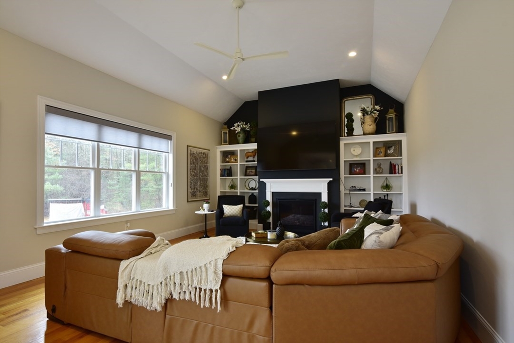 5 Tailwind Circle Norfolk, MA 02056 - Photo 14 of 40 a bedroom with a bed a fireplace and a large window