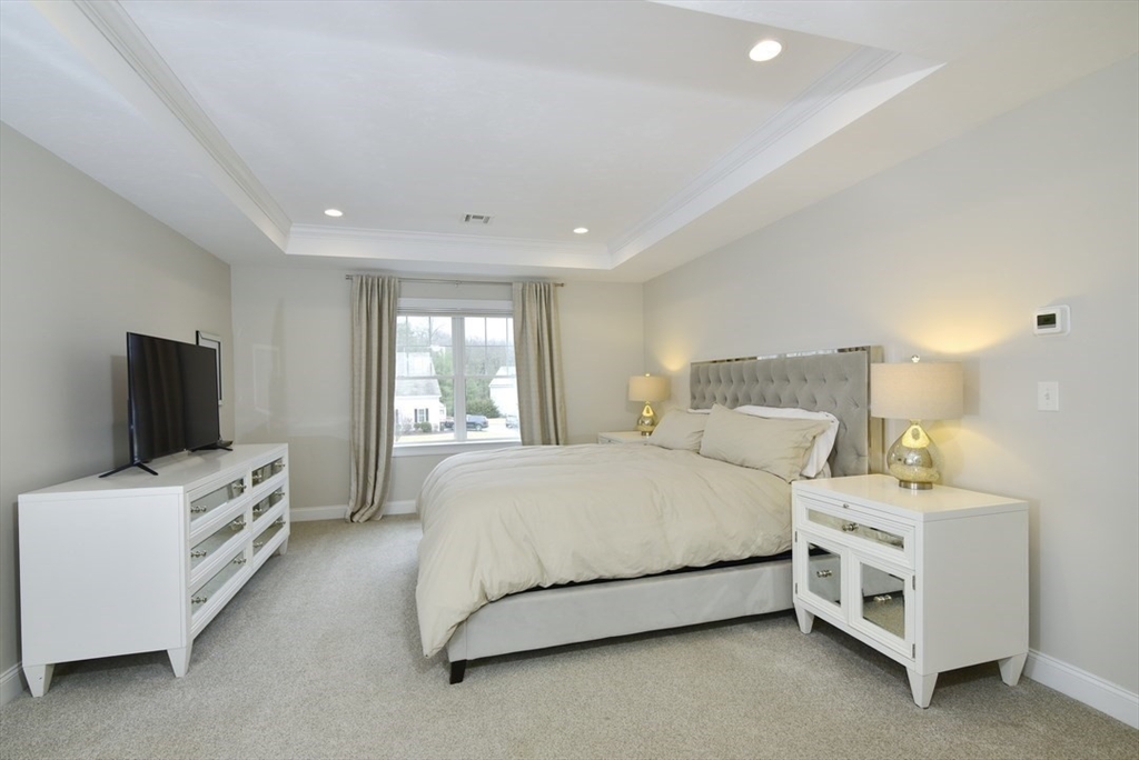 5 Tailwind Circle Norfolk, MA 02056 - Photo 27 of 40 a bedroom with a bed and a flat screen tv