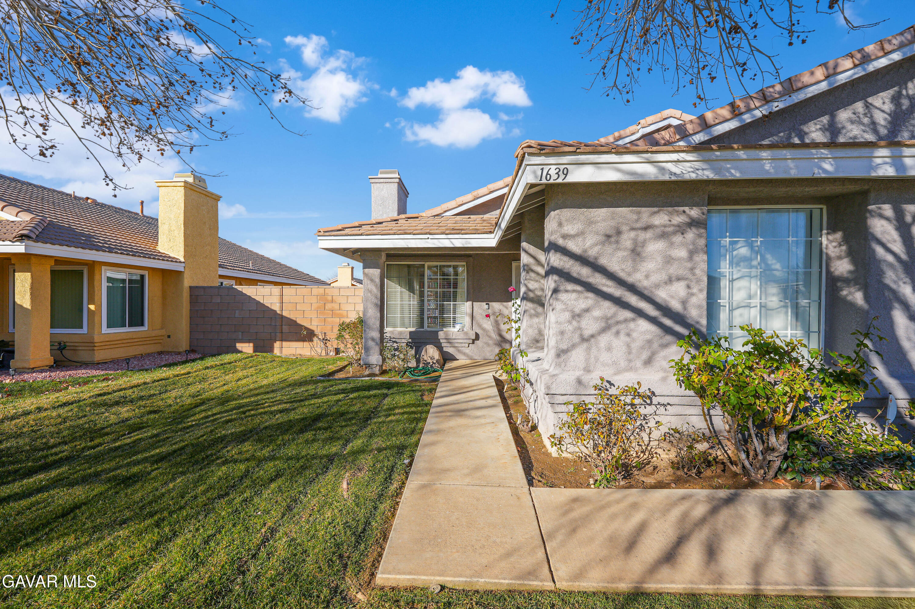 1639 East Kettering Street Lancaster, CA 93535 - Photo 3 of 35 a front view of a house with a yard