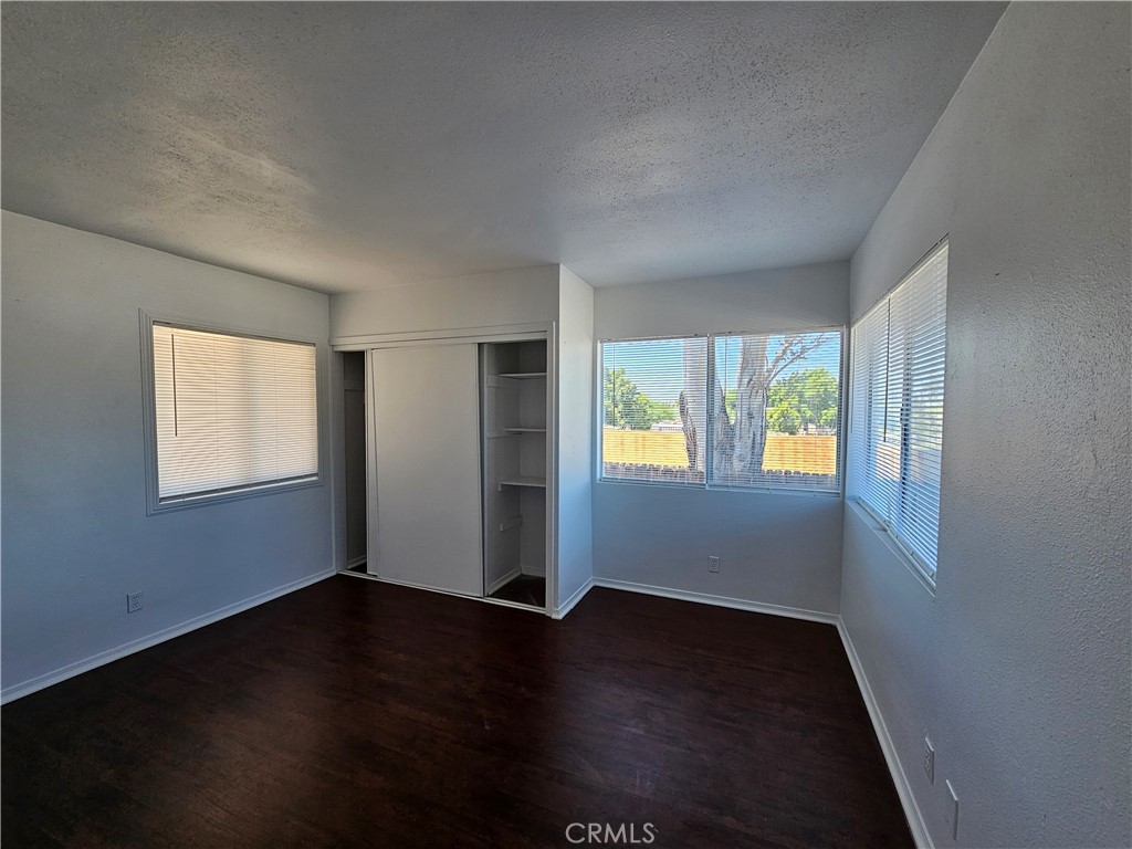 66051 3rd Street, Unit A Desert Hot Springs, CA 92240 - Photo 11 of 14 a view of an empty room with wooden floor and a window