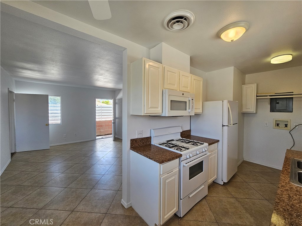 66051 3rd Street, Unit A Desert Hot Springs, CA 92240 - Photo 5 of 14 a kitchen with stainless steel appliances a stove a sink and a refrigerator