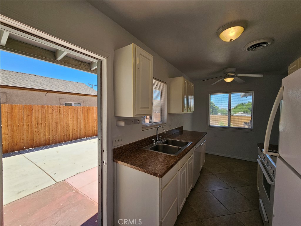 66051 3rd Street, Unit A Desert Hot Springs, CA 92240 - Photo 6 of 14 a kitchen with a sink and a refrigerator