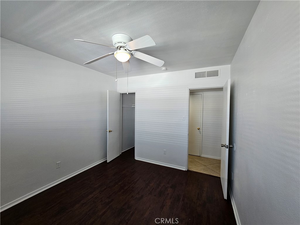 66051 3rd Street, Unit A Desert Hot Springs, CA 92240 - Photo 9 of 14 an empty room with wooden floor and ceiling fan