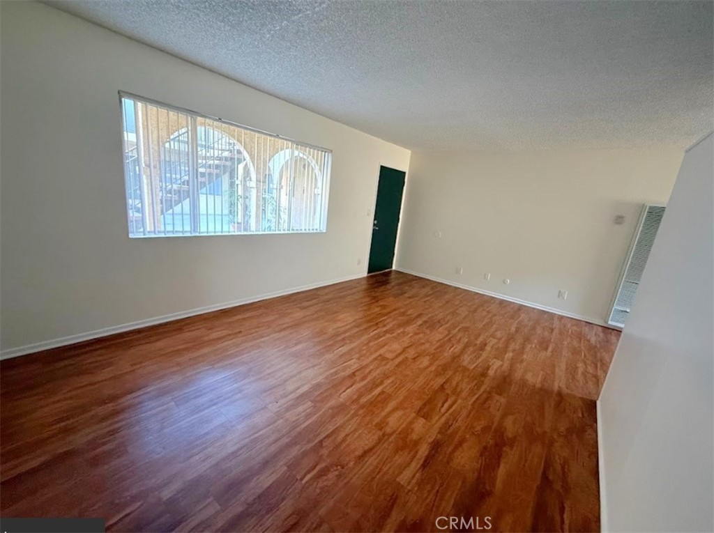 4015 137th Street, Unit 102 Hawthorne, CA 90250 - Photo 11 of 21 an empty room with wooden floor and windows