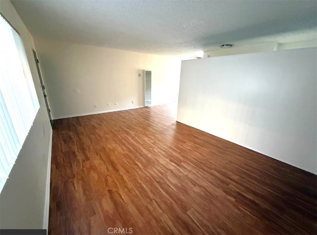 4015 137th Street, Unit 102 Hawthorne, CA 90250 - Photo 9 of 21 a view of an empty room with wooden floor and a window