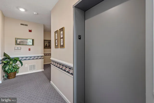 a hallway with a chandelier and livingroom