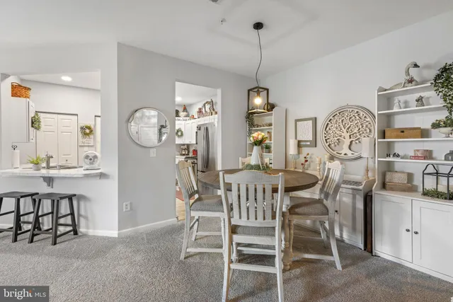 a living room with furniture kitchen view and a window