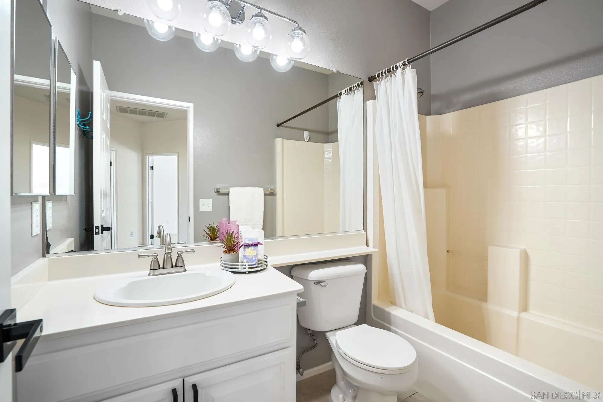 1137 Pacifica Place Encinitas, CA 92024 - Photo 19 of 31 a bathroom with a sink a toilet a mirror a vanity and shower