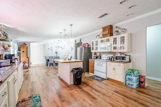 a kitchen with counter top space and wooden floor