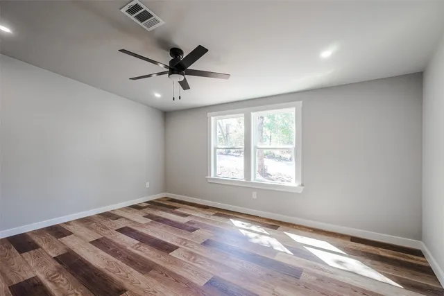 a view of a bedroom with a window and a ceiling fan