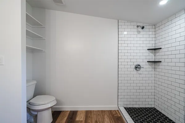 a bathroom with a toilet and a shower