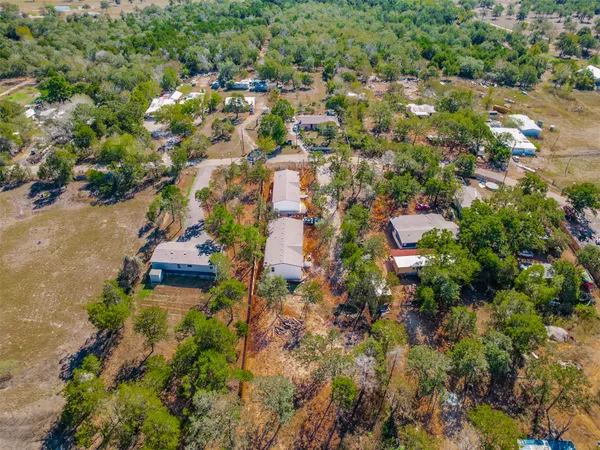 an aerial view of residential house with outdoor space and trees all around