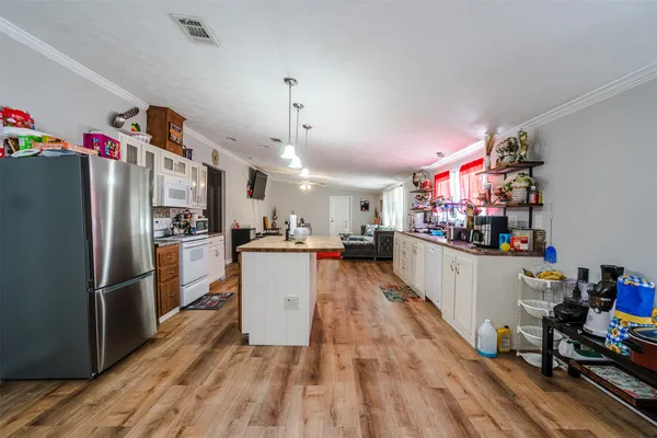 a kitchen with refrigerator and wooden floor