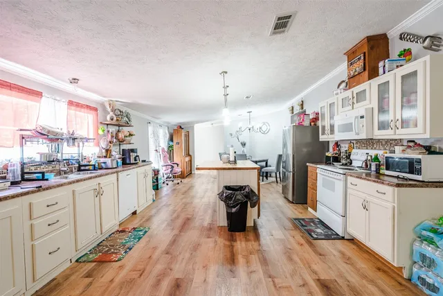a large white kitchen with cabinets