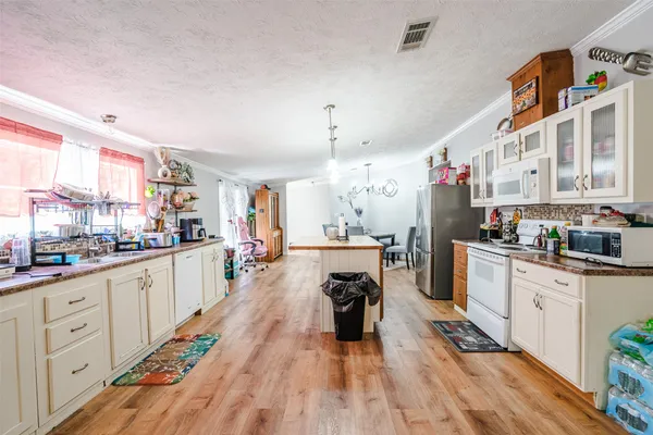 a large white kitchen with cabinets