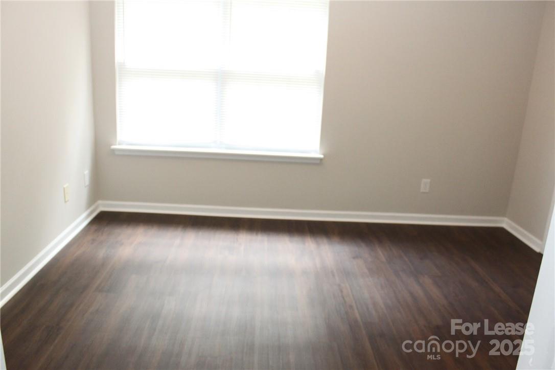 17013 Turning Stick Court Charlotte, NC 28213 - Photo 25 of 27 an empty room with wooden floor and windows