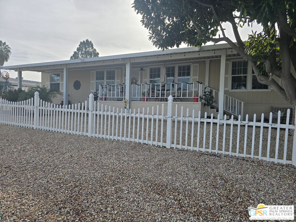 a view of a house with a small yard and wooden fence