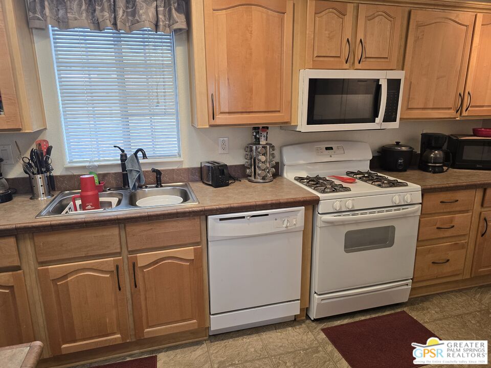 26012 Chelsea Way Hemet, CA 92544 - Photo 8 of 27 a kitchen with cabinets appliances a sink and a window