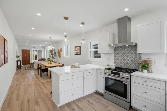 a kitchen with white cabinets and sink