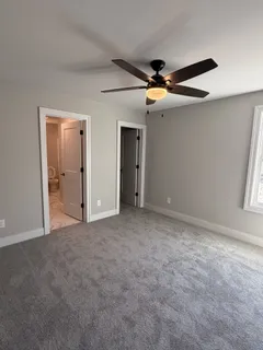 en empty room with windows and ceiling fan