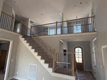 a view of staircase with railing and a chandelier