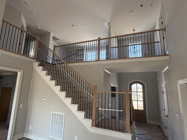a view of staircase with railing and a chandelier